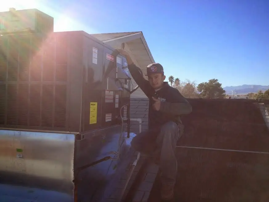 HVAC technician performing Boiler Repair on a rooftop unit in Canfield